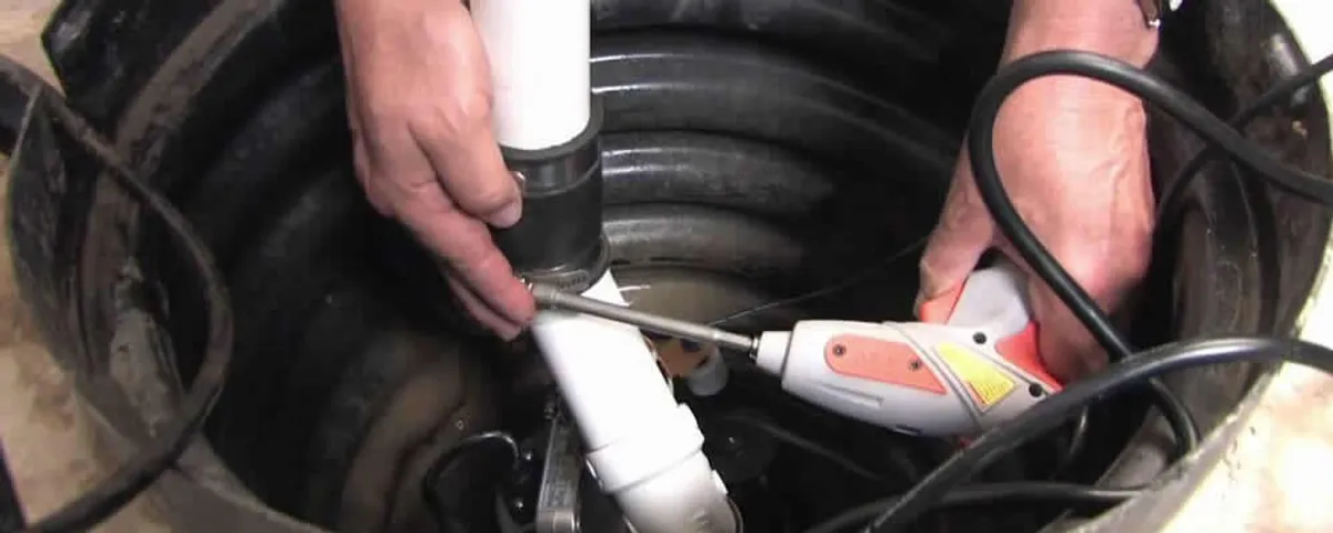 Sump pump installation technician connecting PVC discharge piping in Hartford, CT